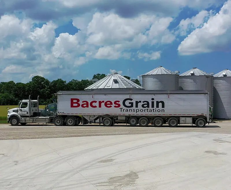 A Bacres Grain Transportation truck parked by the grain bins