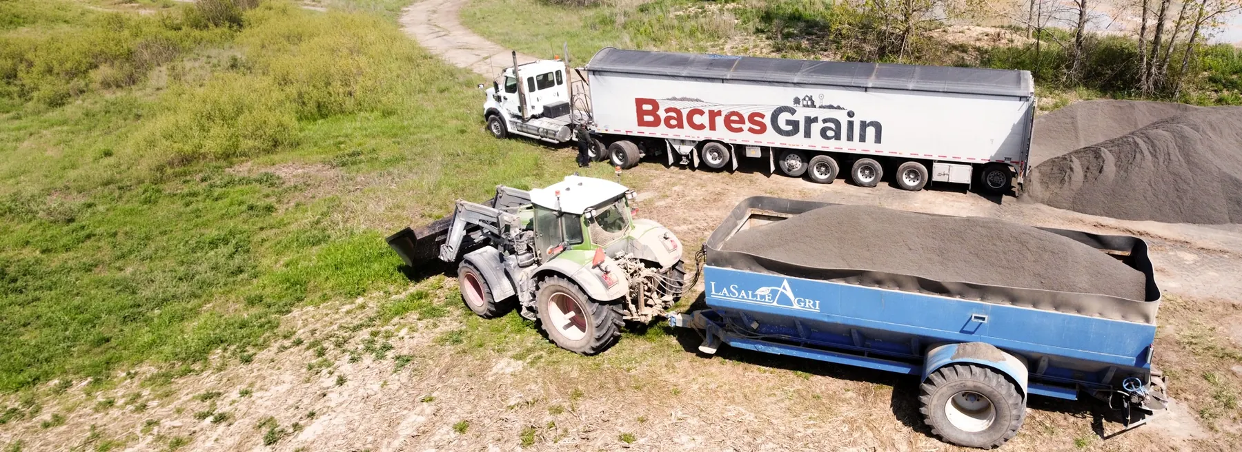 A Bacres Grain Transportation truck beside a fertilizer spreader
